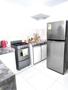 una cucina con piano cottura e frigorifero di "Pacae" House a Ica