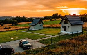 une voiture garée dans un parking à côté de deux petits bâtiments dans l'établissement Lovely Home In Sierpnica With Wifi, à Sierpnica