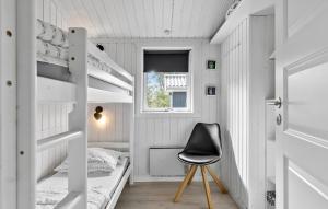 um pequeno quarto com beliches e uma cadeira preta em Gorgeous Home In Jerup With House A Panoramic View em Jerup