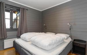 a bed with white sheets in a room with a window at Awesome Apartment In Hemsedal With Kitchen in Hemsedal