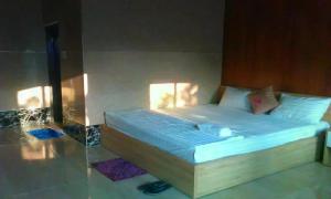 1 dormitorio con 1 cama con pared de cristal en Biển Xanh Homestay, en Ly Son