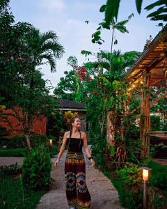 a woman walking down a path in a garden at Terra Luna Lodge in Tena