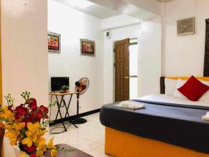 - une chambre avec un lit et une table fleurie dans l'établissement Bag-C Vacation House Bed and Breakfast, à Baguio