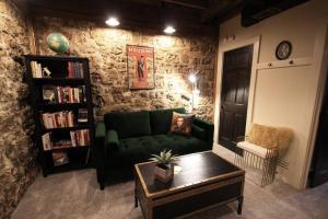 a living room with a green couch and a book shelf at The Owl House in Galena