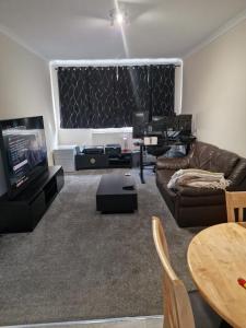 uma sala de estar com um sofá e uma televisão em Cosy Hadleigh em Hadleigh