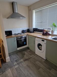 a kitchen with a washing machine and a sink at Cosy Hadleigh in Hadleigh