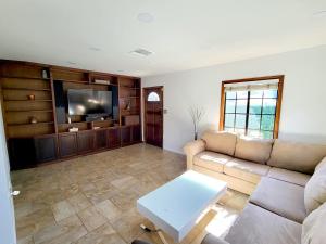 - un salon avec un canapé et une télévision dans l'établissement House In Lake Balboa/Los Angeles, à Los Angeles