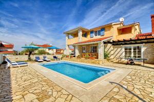 une maison avec une piscine en face d'une maison dans l'établissement Ferienhaus mit Privatpool für 9 Personen ca 200 qm in Gajana, Istrien Istrische Riviera, à Gajana