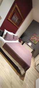 ローマにあるCorrea Vatican Hospitalityのベッドルーム1室(紫のシーツが敷かれた大型ベッド1台付)