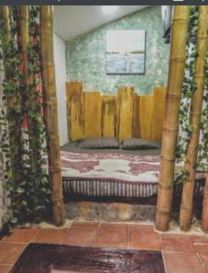 Cama en habitación con postes de bambú en VIEJA ADUANA HOSTAL, en Zipaquirá