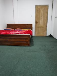 a bedroom with a bed and a wooden door at Traveler's Choice in Nuwara Eliya