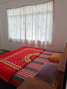 a bed in a room with a window at Traveler's Choice in Nuwara Eliya