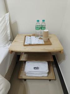 een tafel met handdoeken en flessen water naast een bed bij Yue Xi B&B in Jinhu