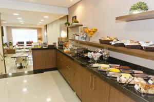 a kitchen with a counter with food on it at Hotel Sol By MRHotelaria in Curitiba