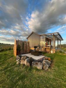 a building with a tub in the middle of a field at Romantic hilltop hideaway - Skyview Cottage in Dairy Flat