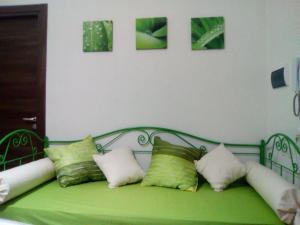 eine grüne Bank mit Kissen auf dem Zimmer in der Unterkunft Studio für 3 Personen ca 40 qm in Alcamo, Sizilien Nordküste von Sizilien in Alcamo
