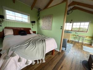 - une chambre avec un lit dans une pièce aux murs verts dans l'établissement Romantic hilltop hideaway - Skyview Cottage, à Dairy Flat