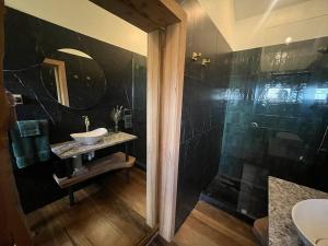 La salle de bains est pourvue d'un lavabo et d'une douche. dans l'établissement Romantic hilltop hideaway - Skyview Cottage, à Dairy Flat