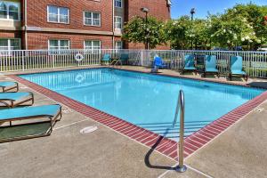 una grande piscina con sedie blu e un edificio di Residence Inn Memphis Germantown a Memphis