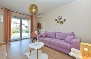 sala de estar con sofá púrpura y mesa en Ferienwohnung für 4 Personen ca 72 qm in Medulin, Istrien Südküste von Istrien, en Medulin