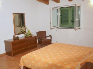 um quarto com uma cama, uma cadeira e um espelho em Ferienwohnung für 6 Personen ca 85 qm in Gioiosa Marea, Sizilien Nordküste von Sizilien em Gioiosa Marea