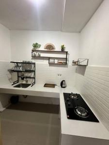 eine weiße Küche mit Herd und Spüle in der Unterkunft Cozy 3BD Home w AC & Netflix in Geutieue
