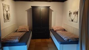 a room with two beds and a cabinet at Ferienwohnung in Horben mit Großem Garten - b43024 in Horben
