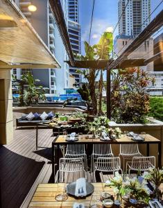 un restaurante con mesas y sillas en un balcón en CBD Central - 1BDR Apt - Sleeps 6 - Sebel 4 Star Resort en Brisbane