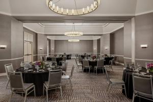 uma sala de banquetes com mesas e cadeiras e um lustre em Sheraton Suites Galleria Atlanta em Atlanta
