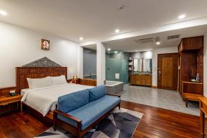 シェムリアップにあるTwo Seasons Siem Reap Hotelのベッドルーム(ベッド1台、青いソファ付)