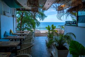 un restaurante con mesas y sillas y vistas al océano en Trinco Beach by DSK en Trincomalee