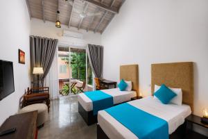 スリ・ジャヤワルダナプラ・コッテにあるAngam Suites Colomboのベッド2台とテレビが備わるホテルルームです。