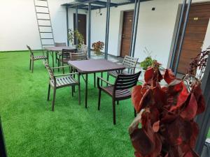 a group of tables and chairs on a patio with grass at Tamora By avea in Madurai
