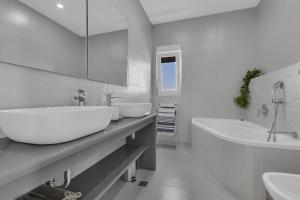 La salle de bains blanche est pourvue de 2 lavabos et d'une baignoire. dans l'établissement Ferienhaus mit Privatpool für 8 Personen ca 340 qm in Makarska, Dalmatien Mitteldalmatien, à Makarska