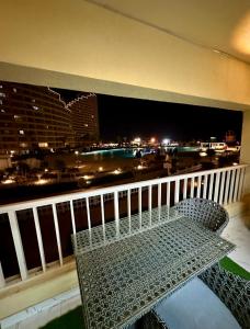 a metal bench on a balcony with a view of a city at شالية VIP باهرامات بورتو السخنة in Ain Sokhna