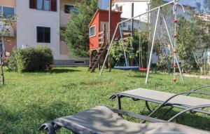 um parque infantil com um baloiço e uma gangorra num quintal em Ferienwohnung für 3 Personen ca 34 qm in Valbandon, Istrien Istrische Riviera em Valbandon
