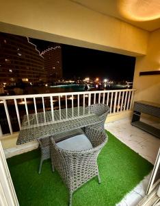 balcón con mesa y sillas en شالية VIP باهرامات بورتو السخنة en Ain Sokhna