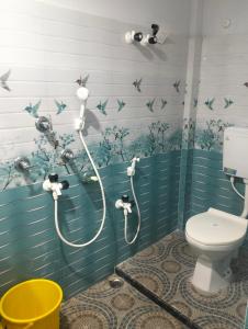 uma casa de banho com duche, WC e pássaros na parede em Motel Day Night Resort em Mādāri Hāt