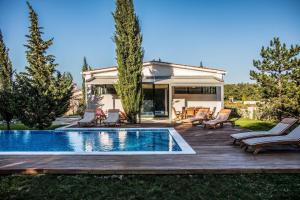 einen Hinterhof mit einem Pool und einer Terrasse mit Stühlen und einem Haus in der Unterkunft Ferienhaus mit Privatpool für 6 Personen ca 160 m in Rogocana, Istrien Bucht von Raša in Raša