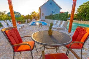 a patio with a table and chairs and a pool at Ferienhaus mit Privatpool für 12 Personen ca 202 qm in Lovrec, Dalmatien Dalmatinisches Hinterland in Lovreć