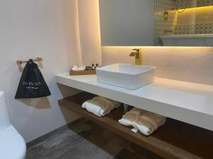 a bathroom with a sink and a mirror and towels at Hotel Boutique Divino Sol in León