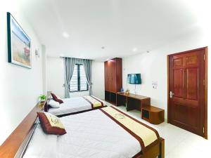 a hotel room with two beds and a television at Lan Quân Hotel in Đảo Cô Tô