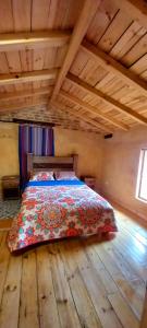 Cama en habitación con suelo de madera en Venta del Espino en Zipaquirá