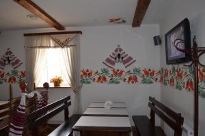 a dining room with a table and chairs with flowers on the wall at Transit Hotel in Dʼyakovtsy