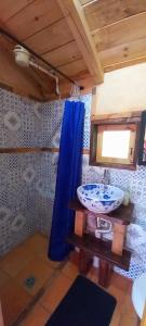 a bathroom with a sink and a blue shower curtain at Venta del Espino in Zipaquirá