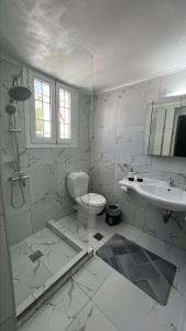 bagno bianco con servizi igienici e lavandino di JET, luxury appartment 20m from the beach a Kinion