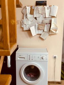 lavadero con lavadora y pared con papel en Sky Guest House, en Tiflis
