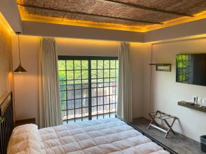 a bedroom with a large bed and a large window at Hotel Boutique Divino Sol in León