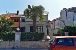 a car parked in front of a house with a palm tree at Ferienwohnung für 3 Personen ca 20 qm in Fažana, Istrien Istrische Riviera in Fažana