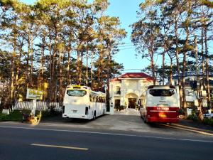 dwa autobusy zaparkowane po stronie ulicy w obiekcie Vân Dương hotel w mieście Kon Von Kla